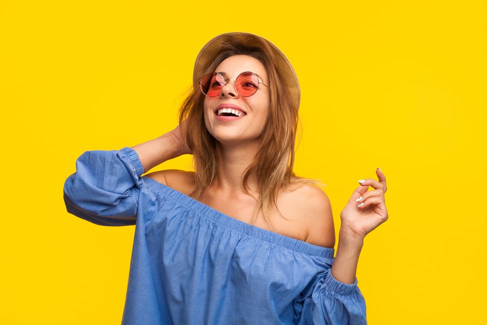 Excited trendy woman laughing on orange